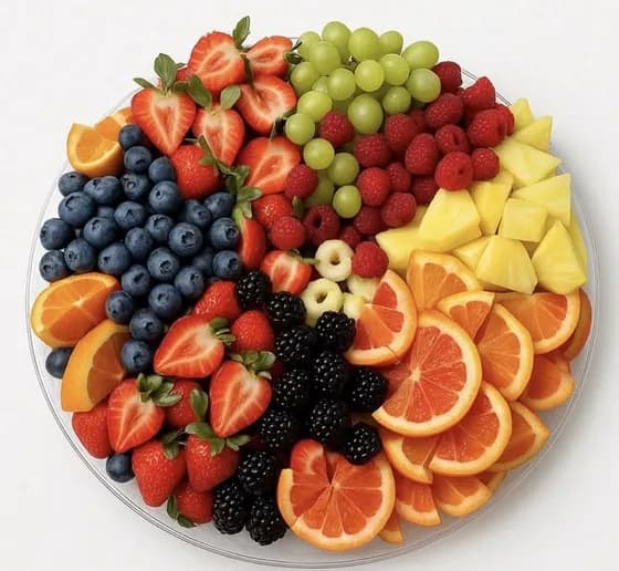 A colourful Eat Good Club fresh fruit platter of berries, grapes, pineapple and orange.
