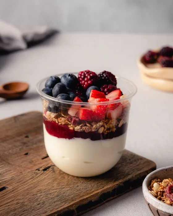 An Eat Good Club yogurt cup layered with granola, blueberries and strawberries.